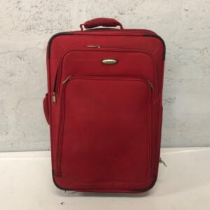 Red soft-sided wheeled suitcase — HERO badge, front pockets, wheels roll (62 x 24 x 40 cm)