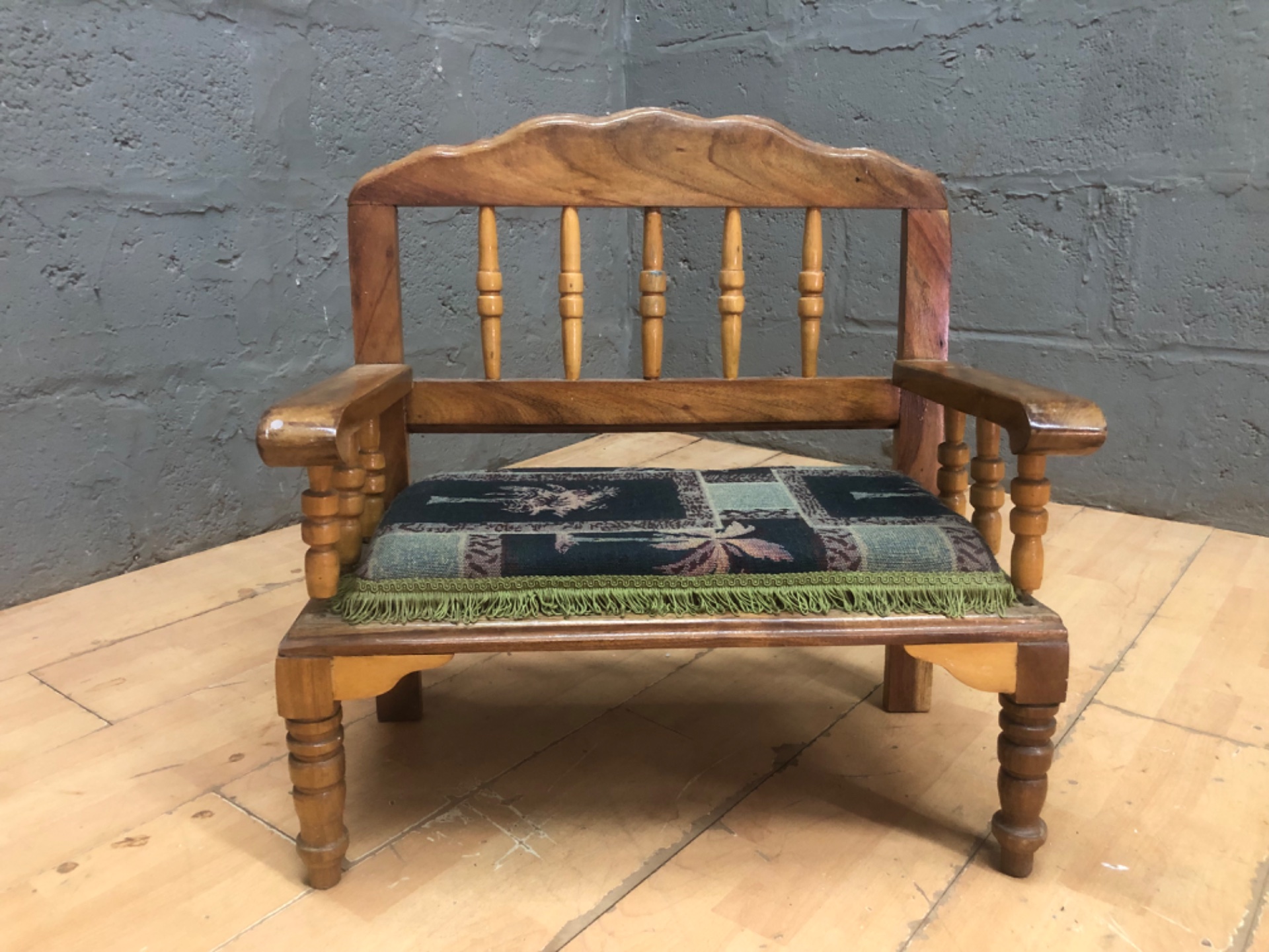 Small wooden child’s armchair with upholstered seat and turned spindles