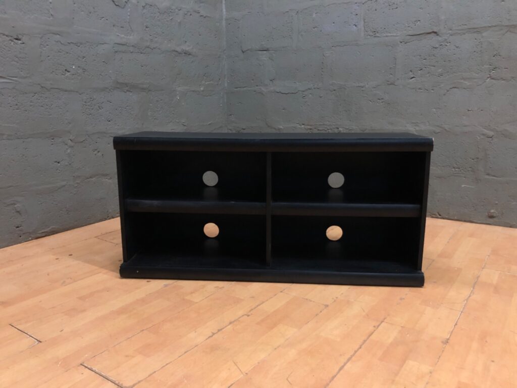 Black low media shelf / TV unit — 4 cubbies, cable holes, 58 x 36 x 120 (used)
