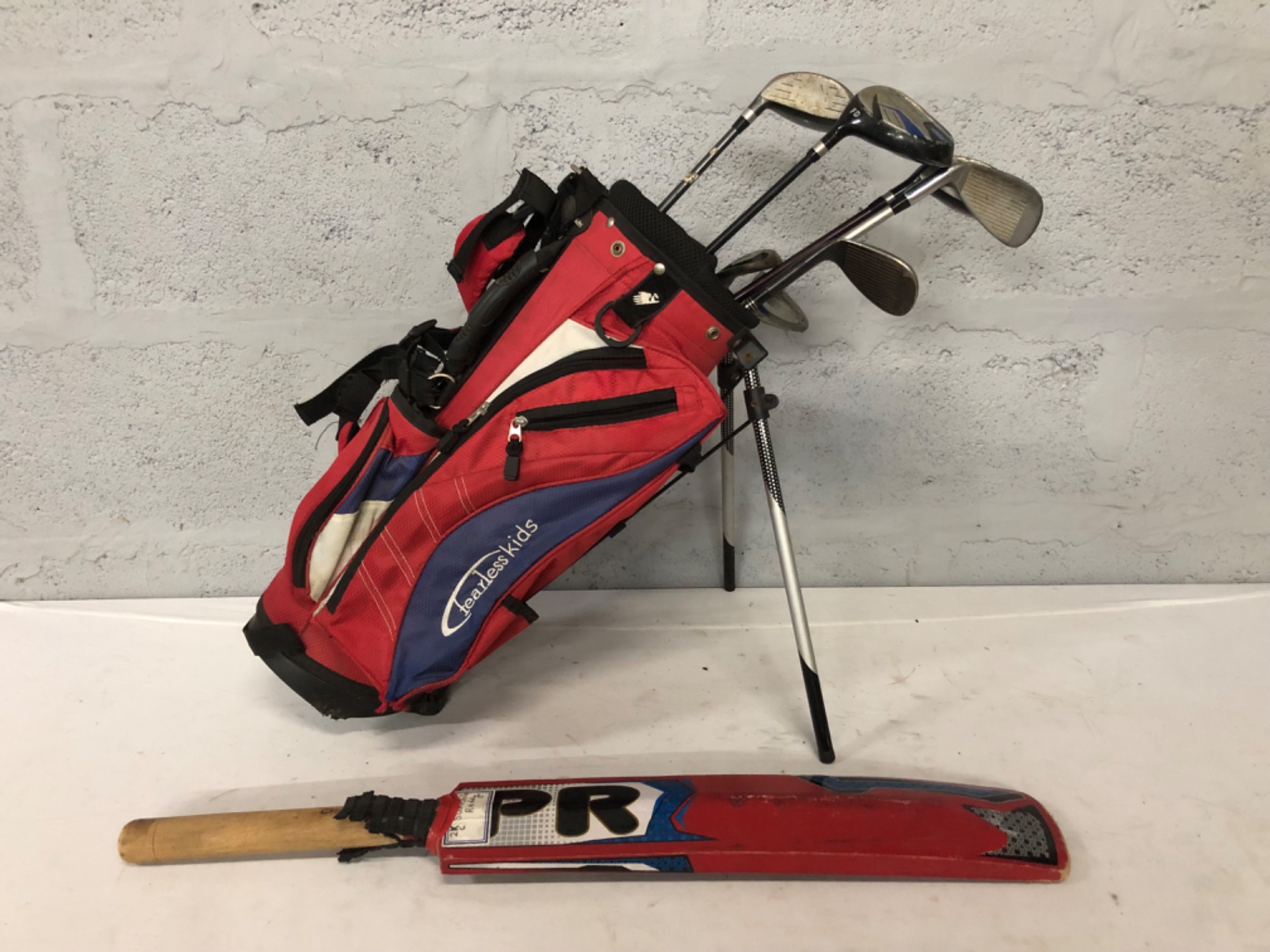 Junior golf set in Headless Kids stand bag + PR cricket bat — used, heavy cosmetic wear