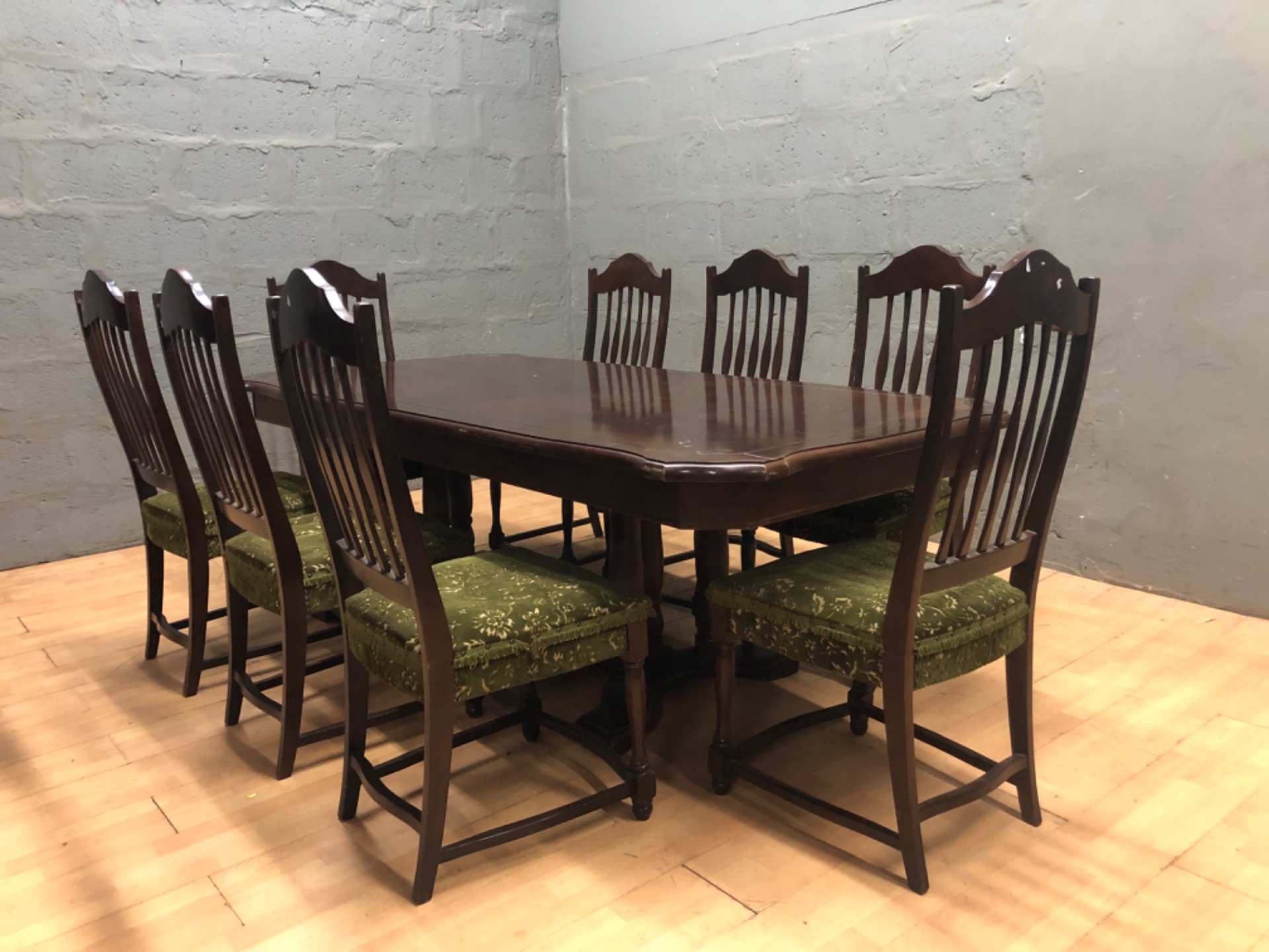 Eight‑seat wooden dining table with 8 matching chairs — green upholstered seats