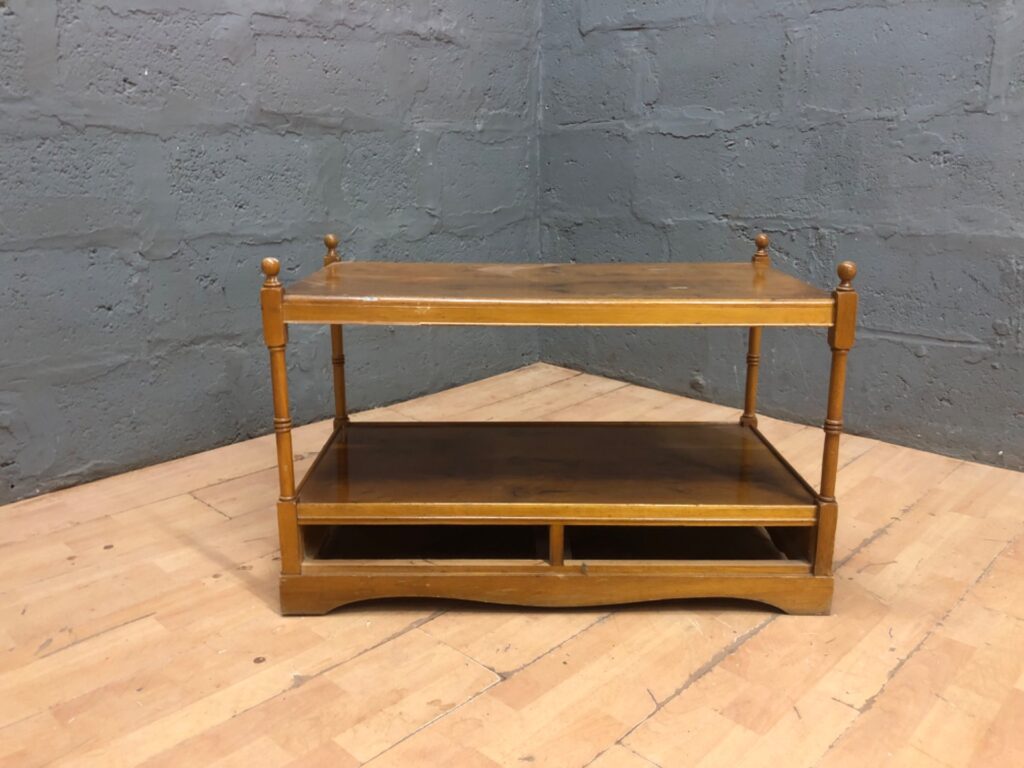 Low three-tier wooden coffee / occasional table with turned legs and open cubby base