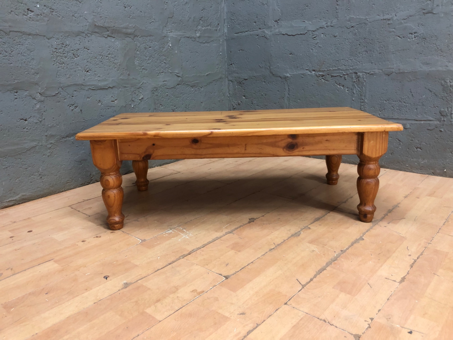 Low pine coffee table — solid wood with turned legs (114 x 59 x 39 cm)