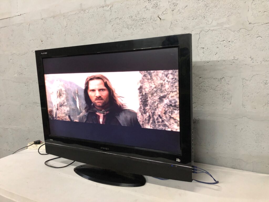 Sansui 42″ LCD TV (SV-4251LCD) — powers on, built-in stand, model label visible