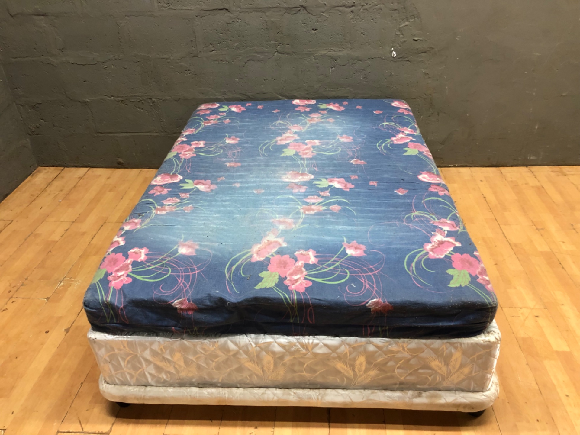 Used sponge-top mattress on divan base (135 x 187 x 53 cm) — floral cover, heavy wear