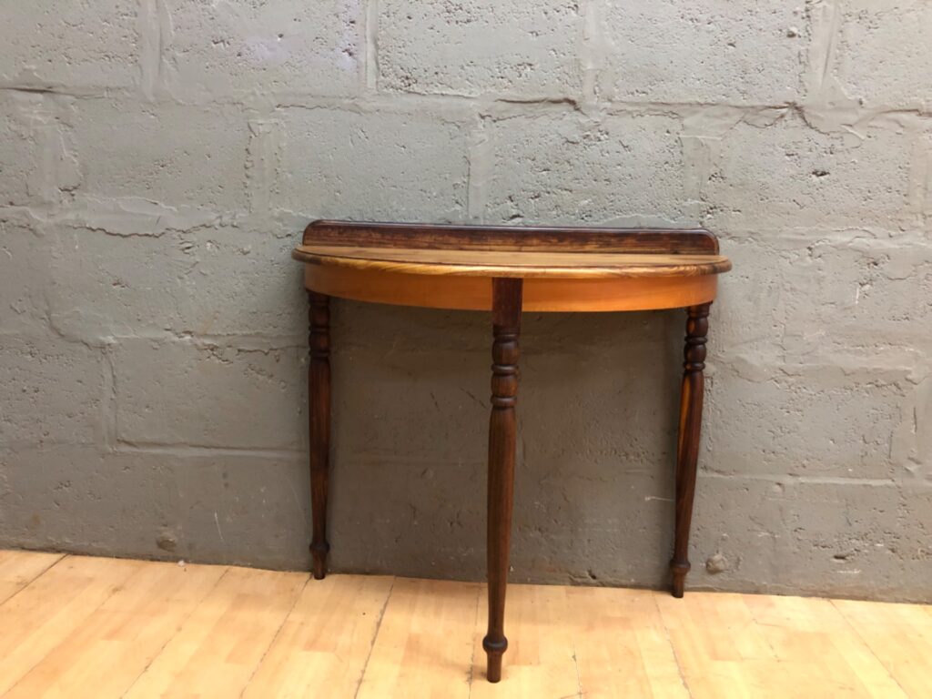 Half‑moon pine demilune console table with raised back rail and turned legs