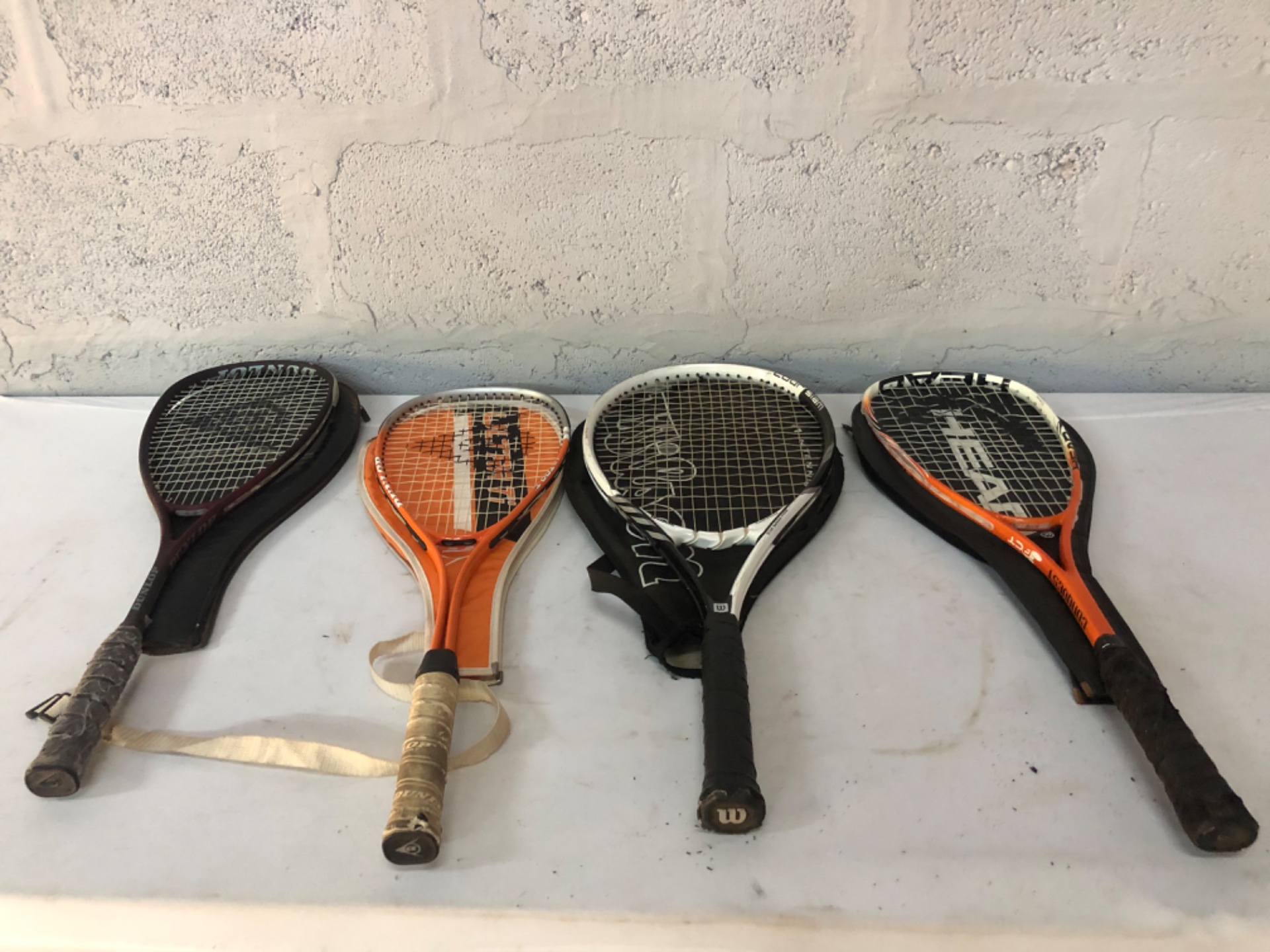Lot of 4 Used Tennis Rackets — Dunlop, Wilson, Head visible (covers included)