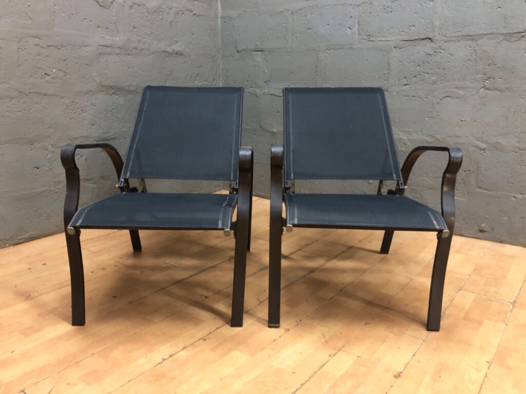 Pair of outdoor reclining metal-frame chairs with black mesh slings — one sling torn, both recline (103 x 73 x 61 cm)