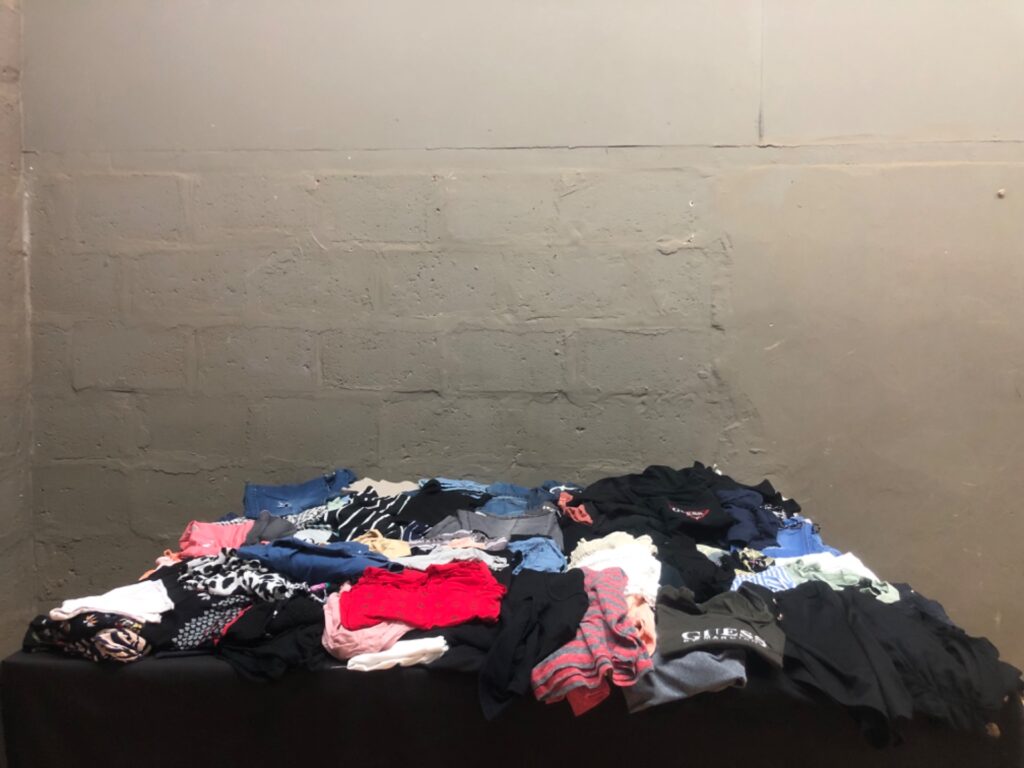 Bulk mixed women’s clothing lot — assorted tops, tees, denim & shorts (used) with visible GUESS tee