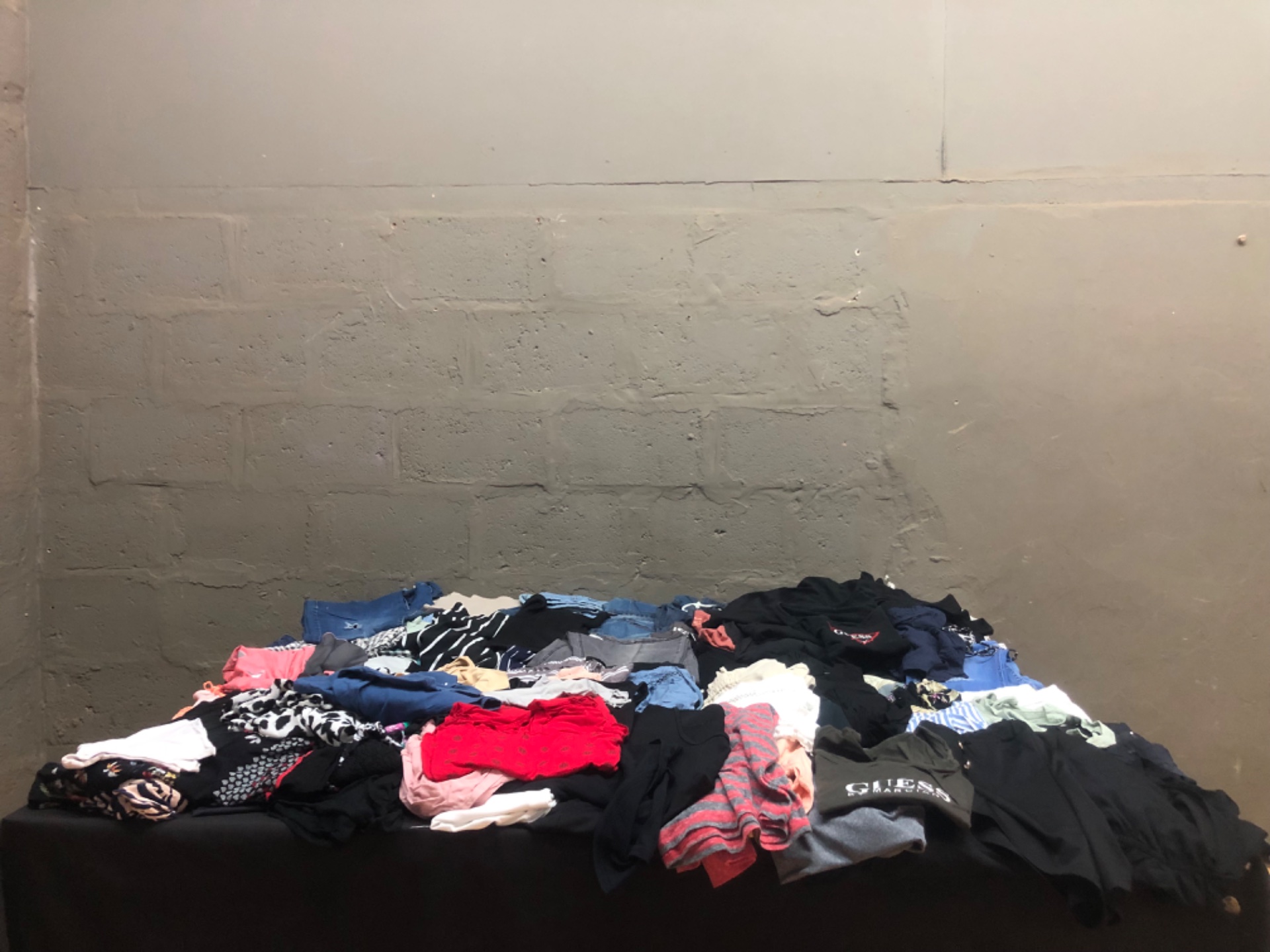 Bulk mixed women’s clothing lot — assorted tops, tees, denim & shorts (used) with visible GUESS tee