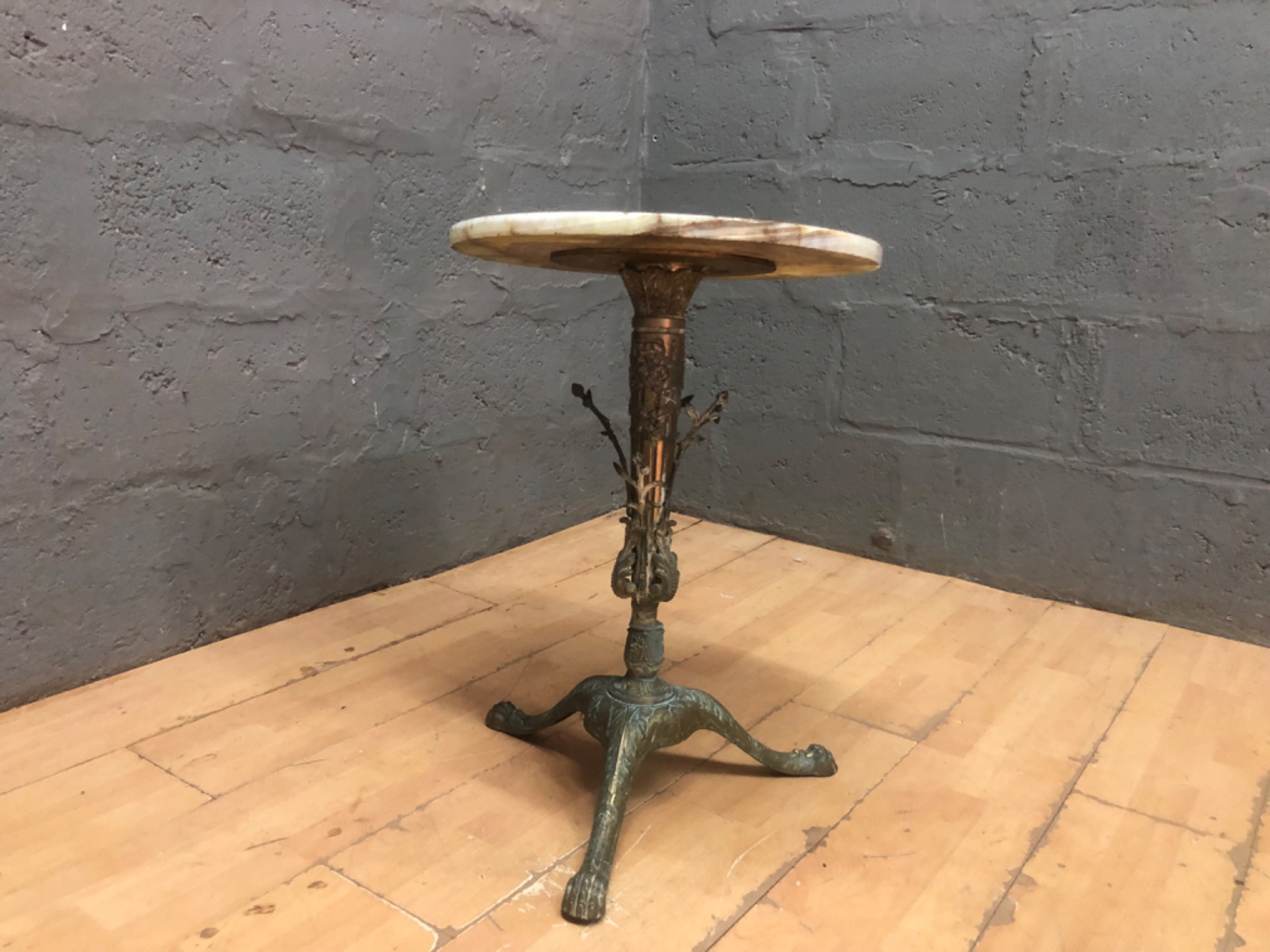 Ornate cast-metal tripod occasional table with veined stone top