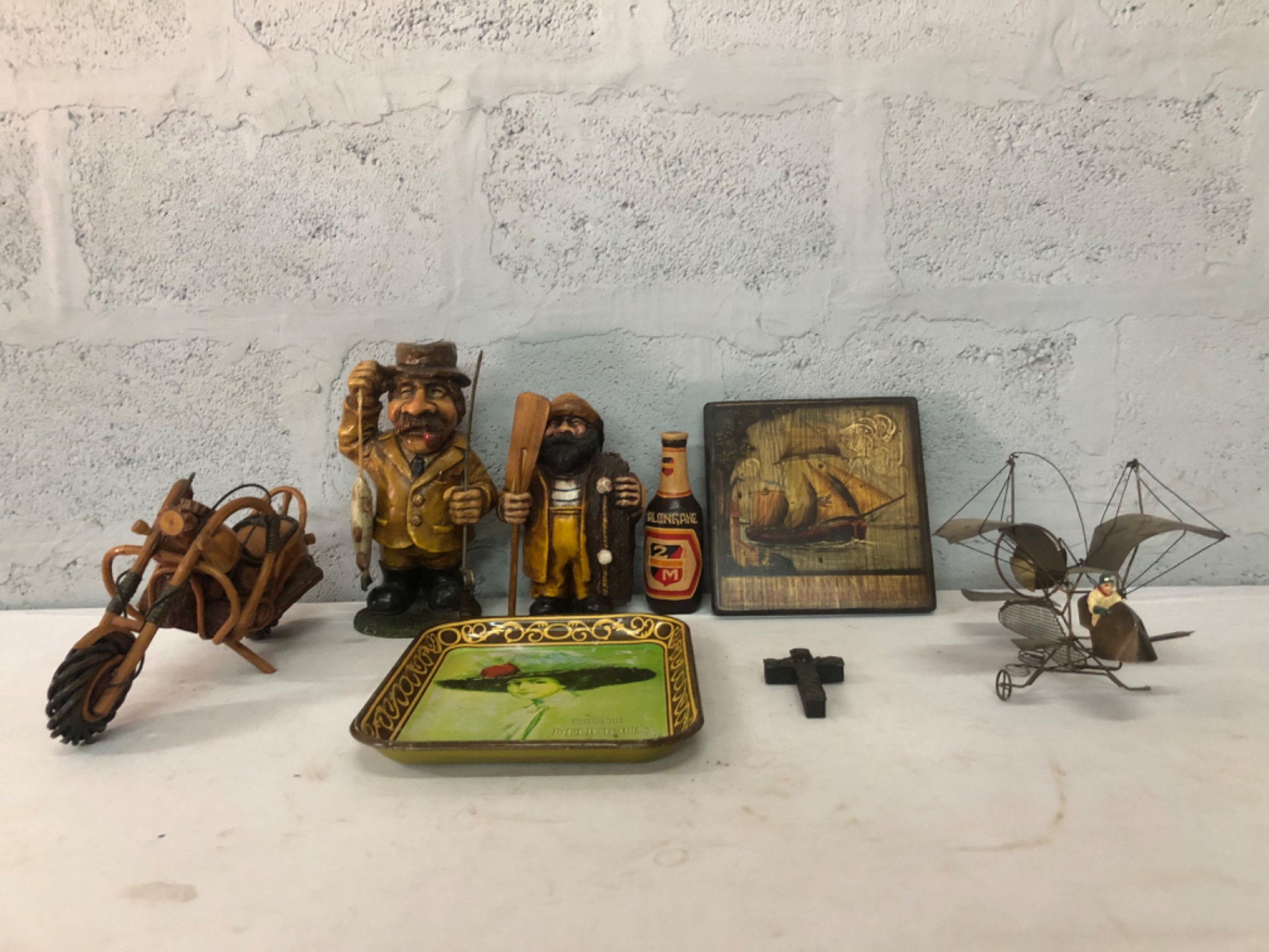 Mixed lot of 8 decorative smalls — Coca‑Cola tin tray, carved fisherman figures, wooden cart, metal flying‑machine & more