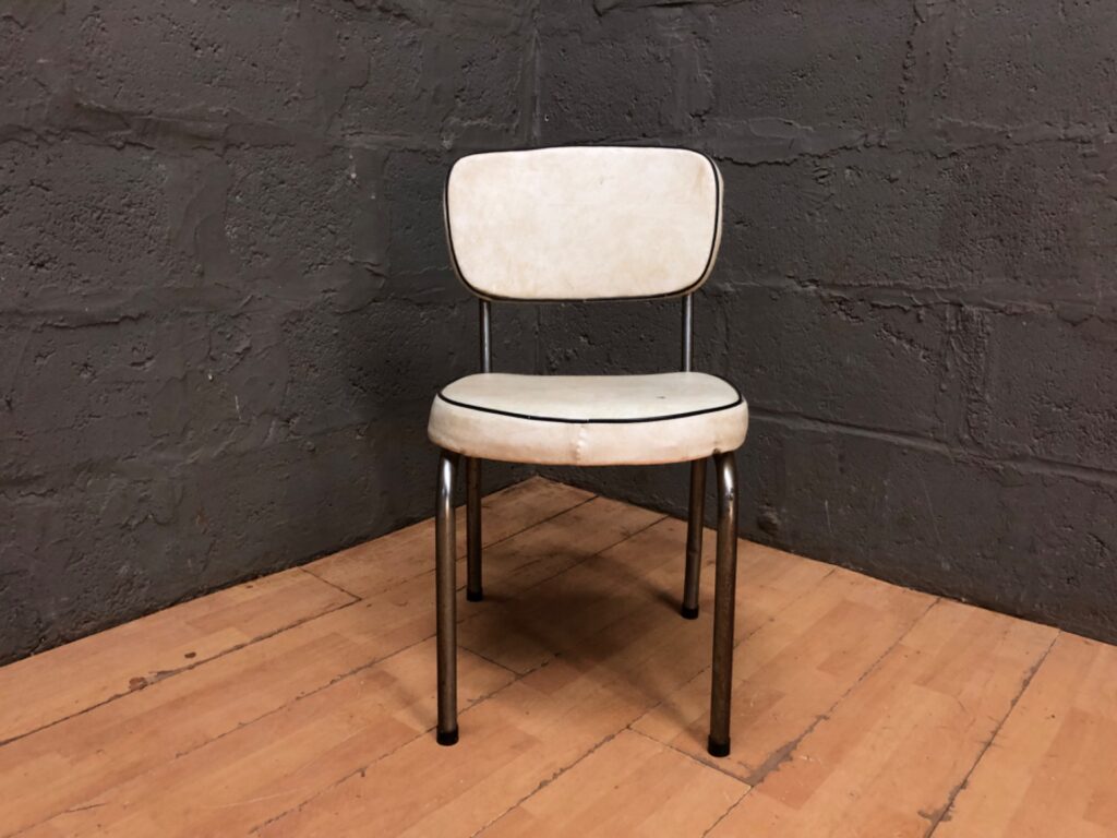 Vintage metal tubular dining/kitchen chair — cream vinyl with black piping, worn