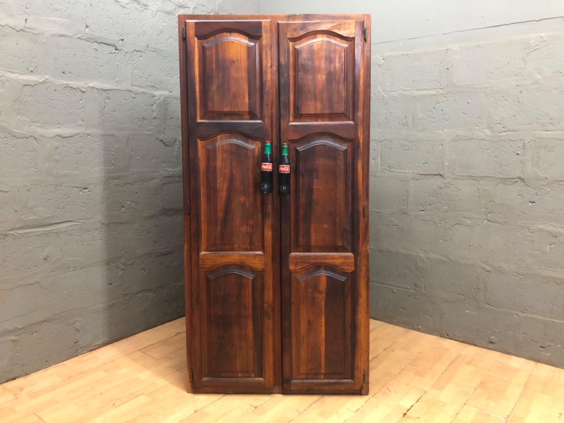 Tall two-door wooden cabinet with novelty Coca-Cola bottle handles, shelves, 190×48×93 cm