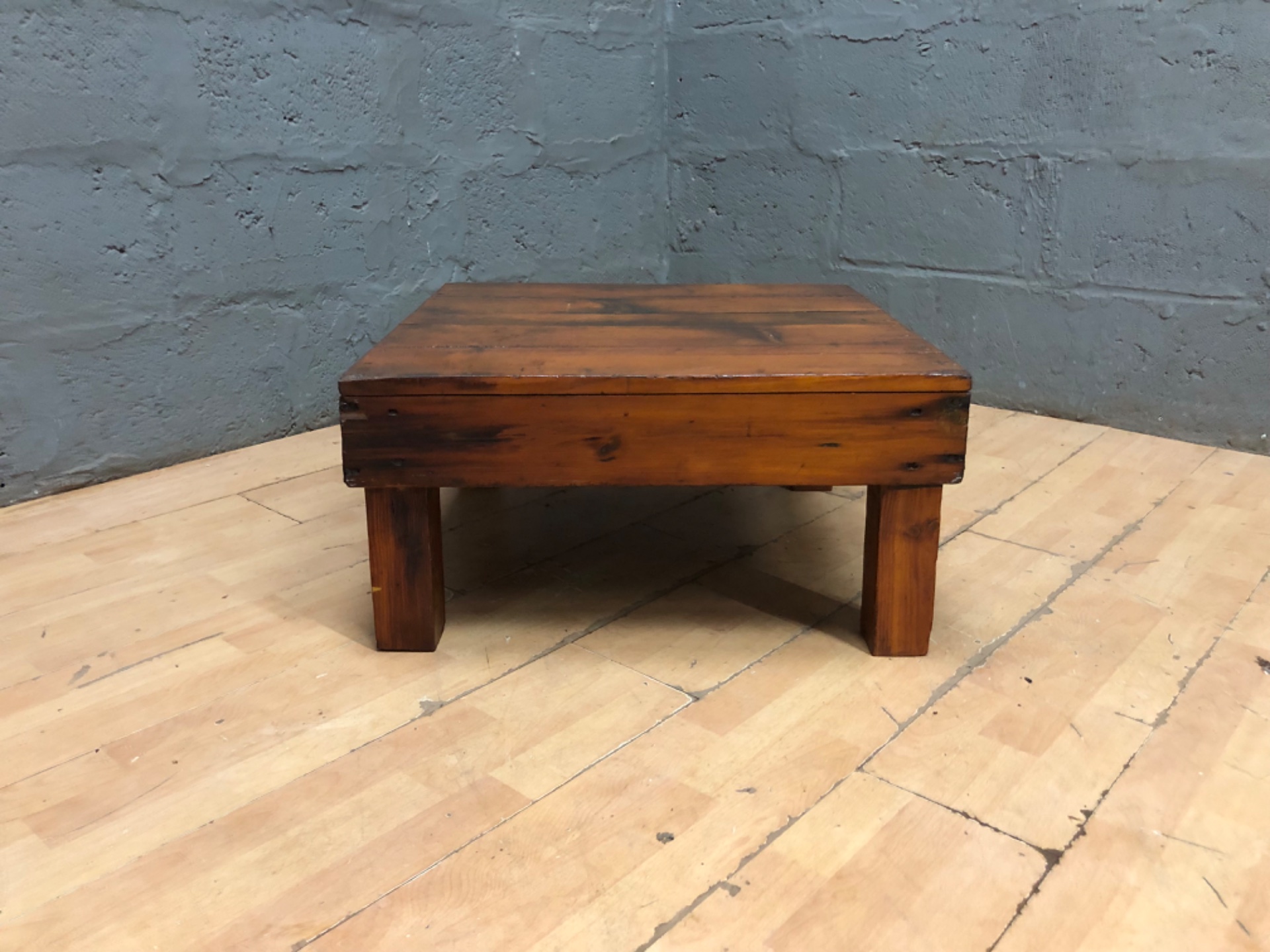 Low rustic wooden coffee/side table — plank top on short block legs (69 × 69 × 34 cm)