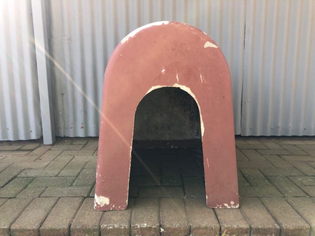 Single-piece concrete outdoor dog kennel / pet house — 68 x 70 x 47 cm — paint peeling, interior soiled