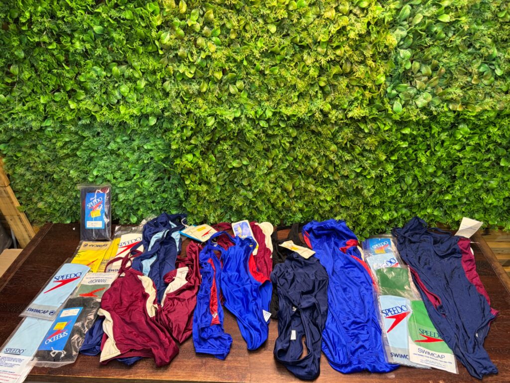 Bulk lot of mixed one‑piece swimsuits with Speedo swim caps (mixed new & used)