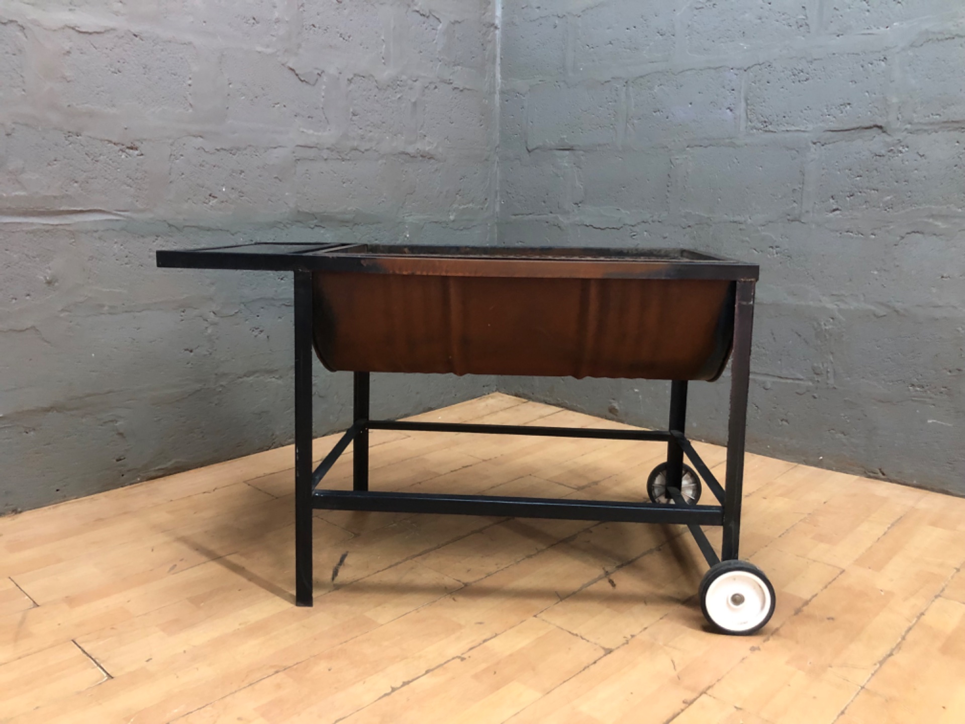 Outdoor wheeled charcoal/wood barbecue brazier on metal trolley with side shelf
