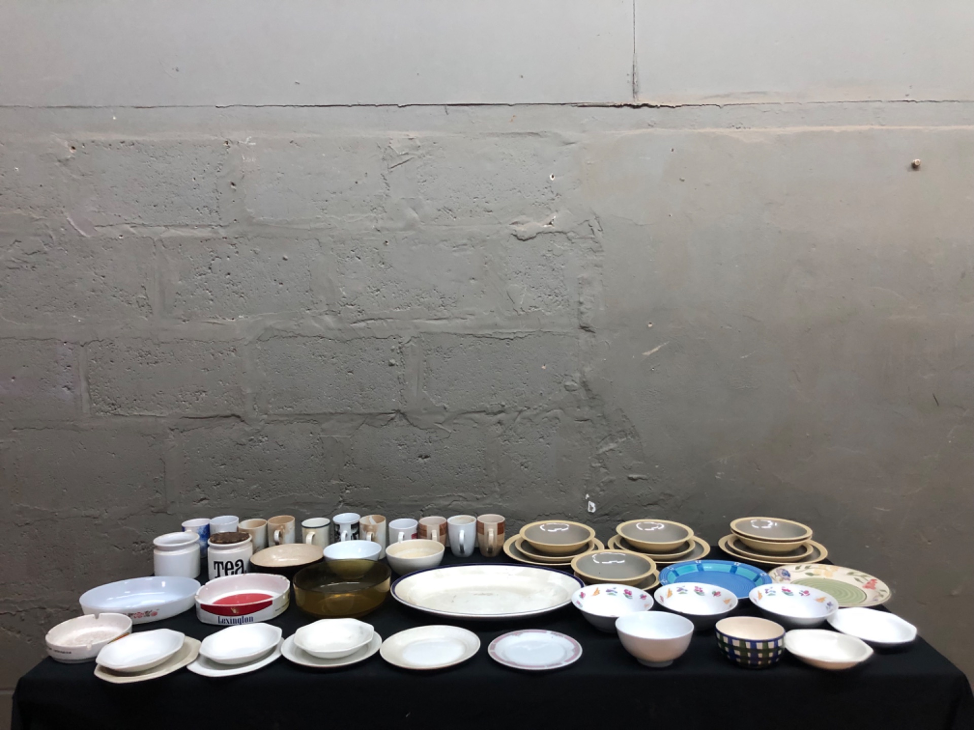Assorted mixed dinnerware lot — approx. 50 ceramic/porcelain plates, bowls, mugs, serving pieces (mixed brands, stained/used)