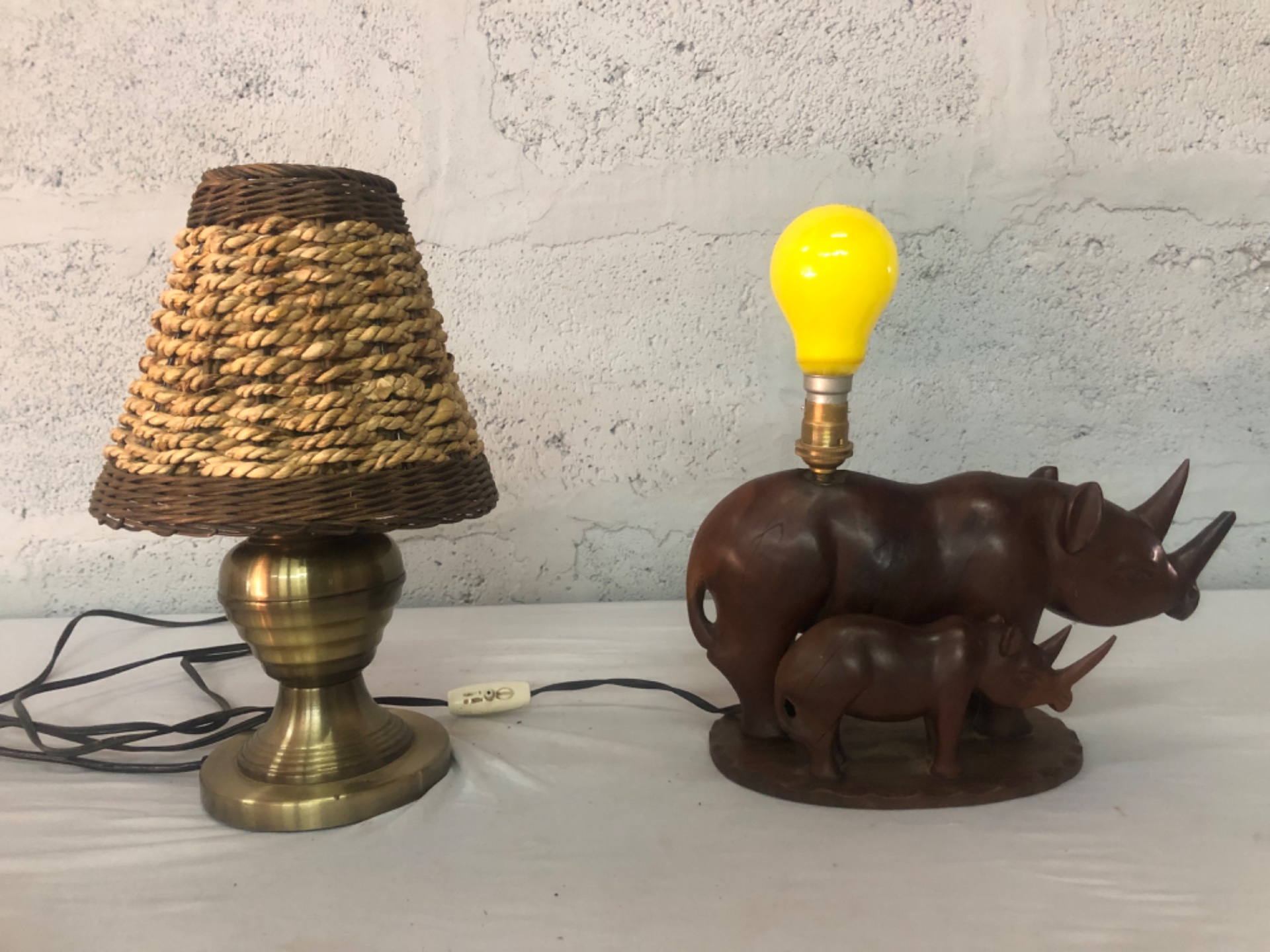 Pair of working table lamps — brass base with woven wicker shade + carved wooden rhino lamp (bulbs included)
