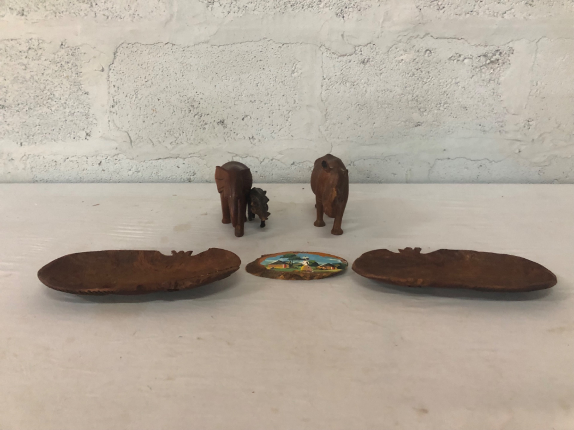 Mixed lot — 6 carved wooden decorative pieces: 2 shallow bark-edge bowls, 2 carved animal figures, painted ‘NEWCASTLE’ plaque + small figurine