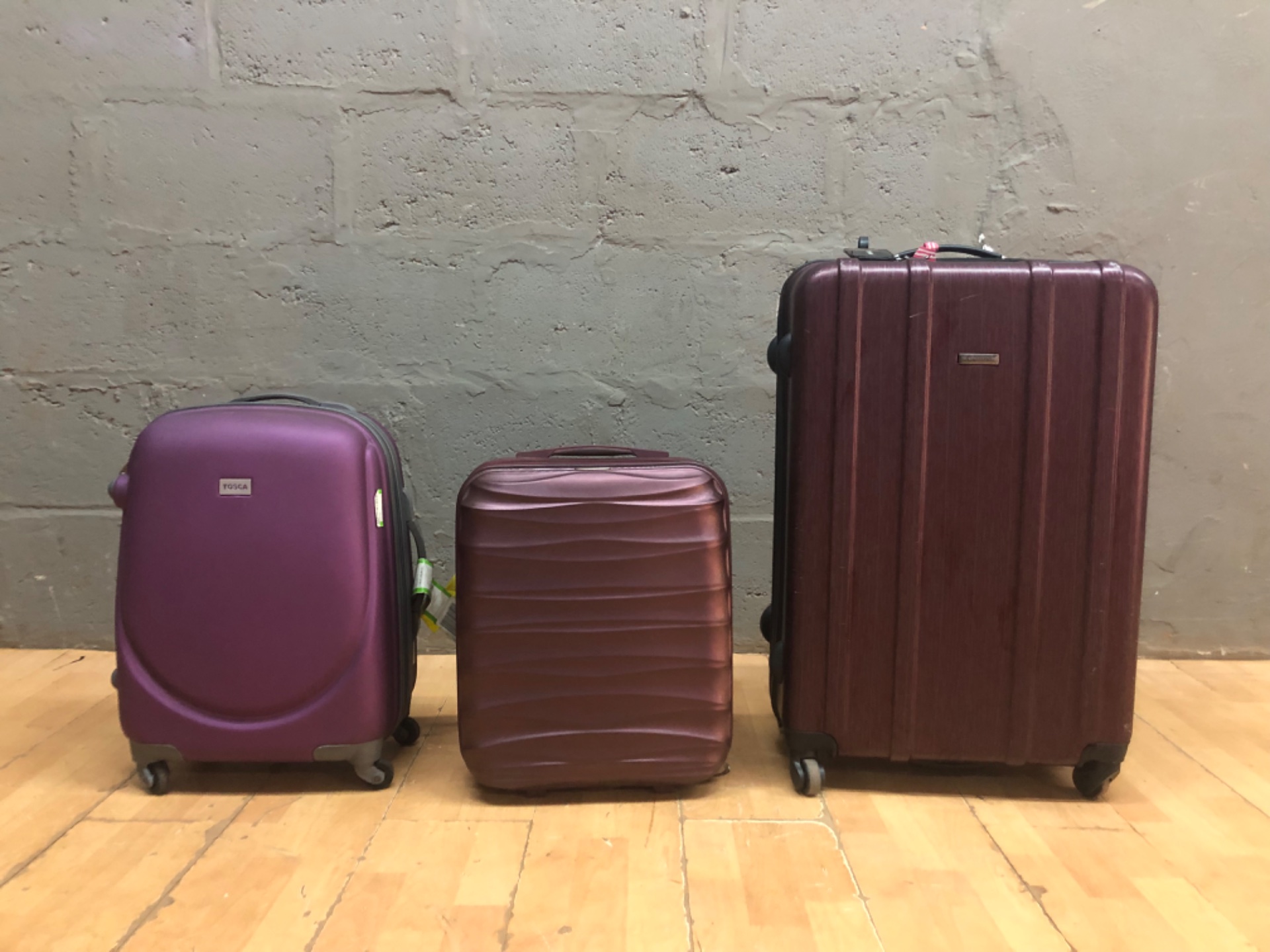 Three-piece hard-shell luggage set — mixed brands (TOSCA, members, E CELLINI) — used, wheels worn