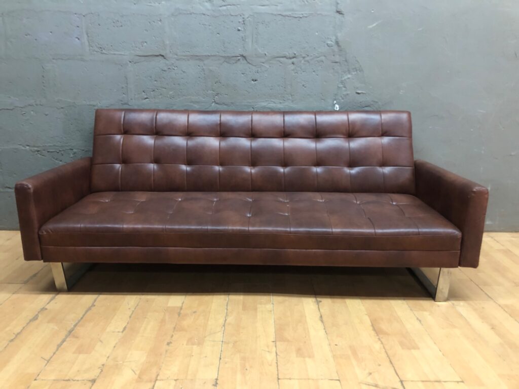 Brown tufted 3-seater genuine leather sofa bed with metal sled legs — converts to bed, visible tears and split seams