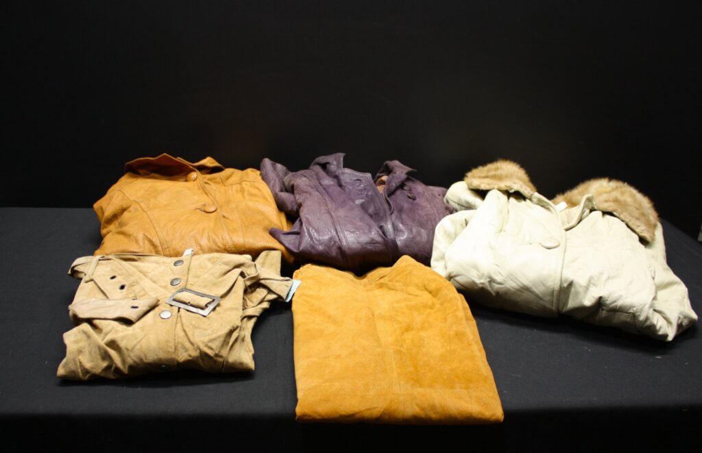 Mixed lot of leather & suede jackets and coat — cream fur-trimmed coat, purple patterned jacket, tan suede pieces (used, visible wear)