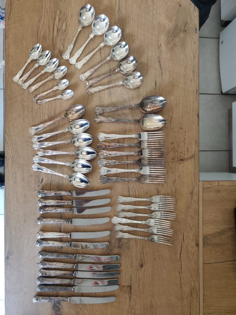 Mixed ornate flatware set — assorted spoons, forks & table knives (mixed condition)