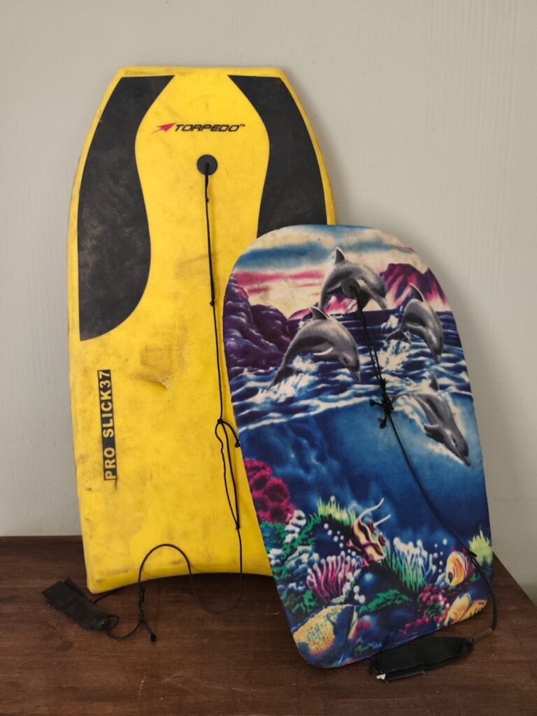 Pair of used bodyboards — Yellow Torpedo Pro Slick 37 + dolphin-covered board (worn, puncture, frayed leashes)