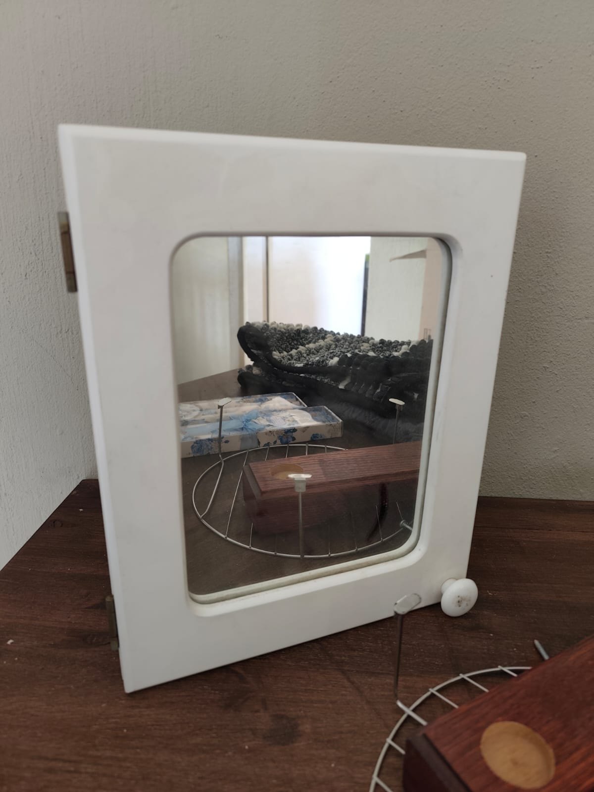 Mixed home lot: white mirrored wall cabinet, wooden display stand, round metal rack, 2 boxed taper candle sets, folded rugs/mats