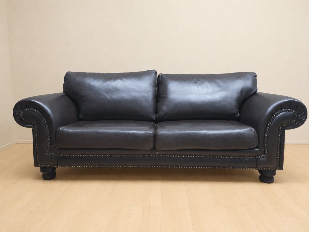 2-seat brown top-grain leather sofa — studded arms, turned feet, removable cushions (240 x 98 x 83 cm)