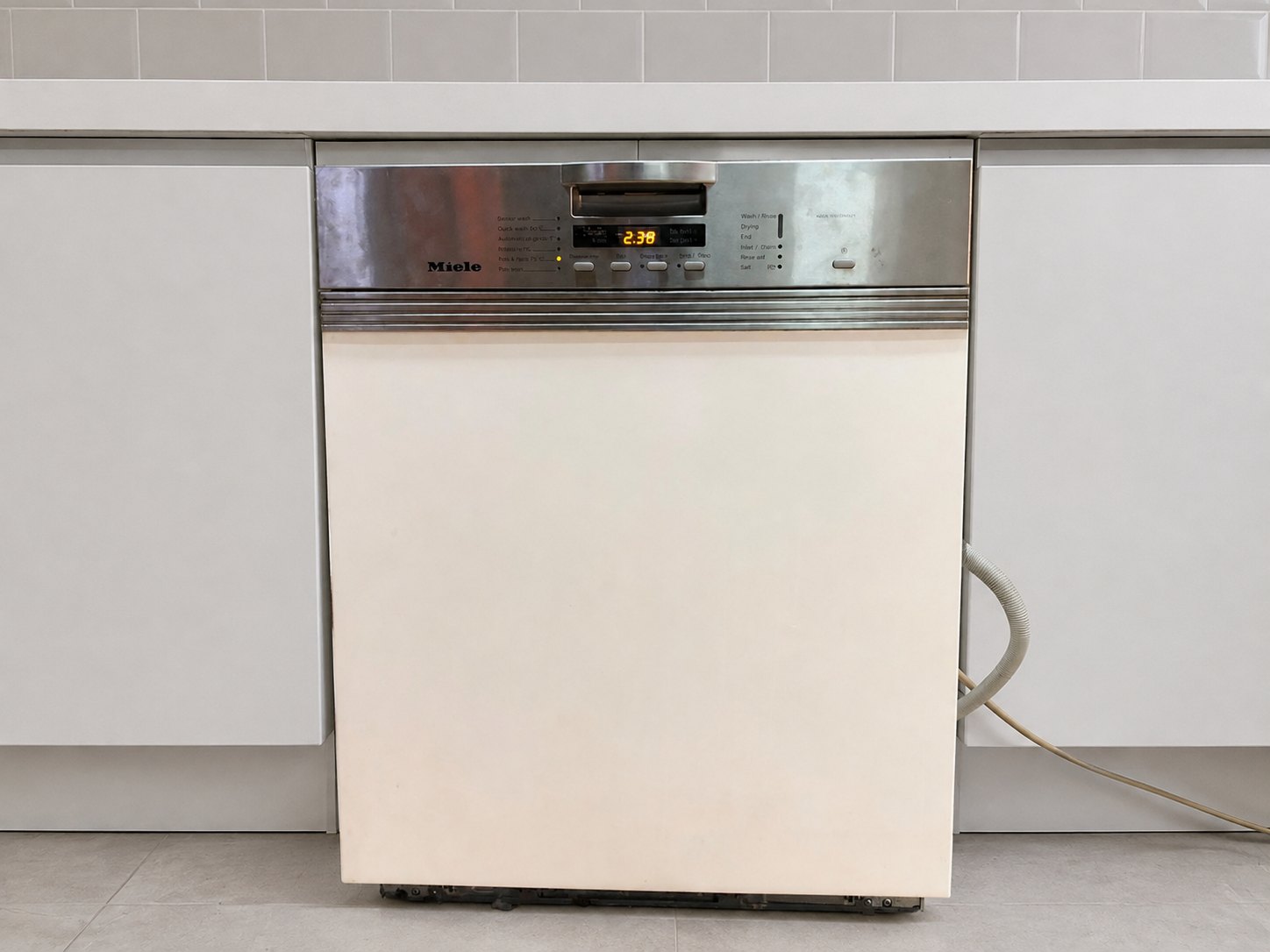 Miele G1220 SCI built-in dishwasher — powers on, racks & hoses, top cover removed, lower kickplate damaged