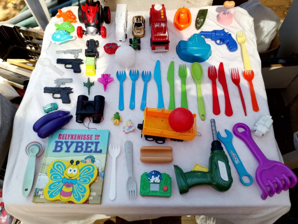 Mixed lot of children’s plastic toys, utensils and small books — approx. 59 pieces, used