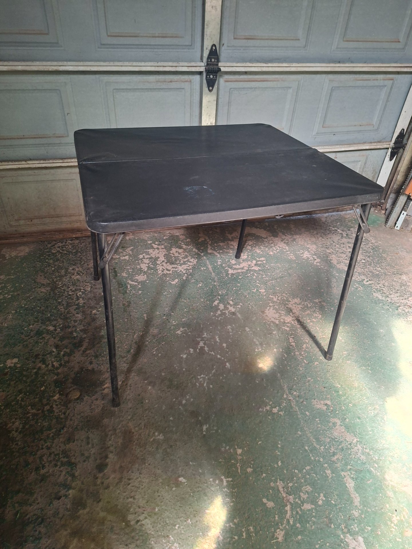Portable folding plastic-top table – black, carry-handle, locking legs (worn)