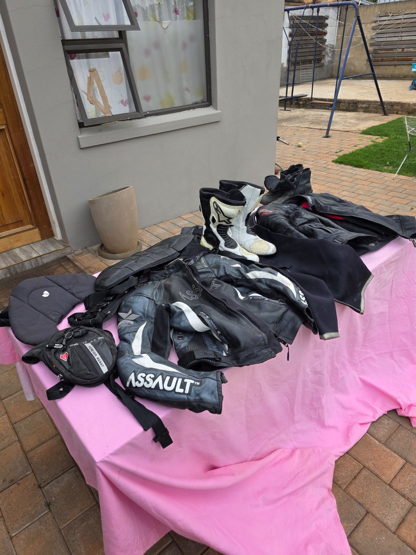 Mixed used motorcycle protective gear lot — 2 leather jackets (ASSAULT, RST) M, 2 boots size 9.5, back protector, small bags, diving suit (as disclosed)