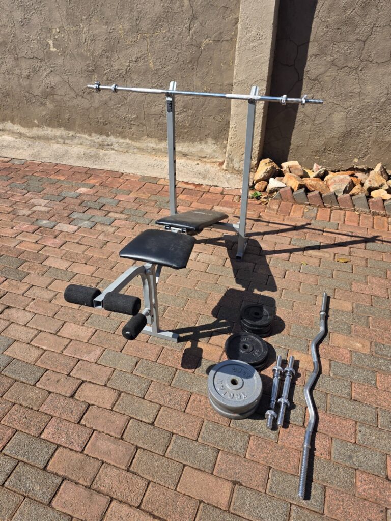 Trojan Performa 300 adjustable bench + free-weight set (Everlast plates) — bars, EZ curl, dumbbell handles