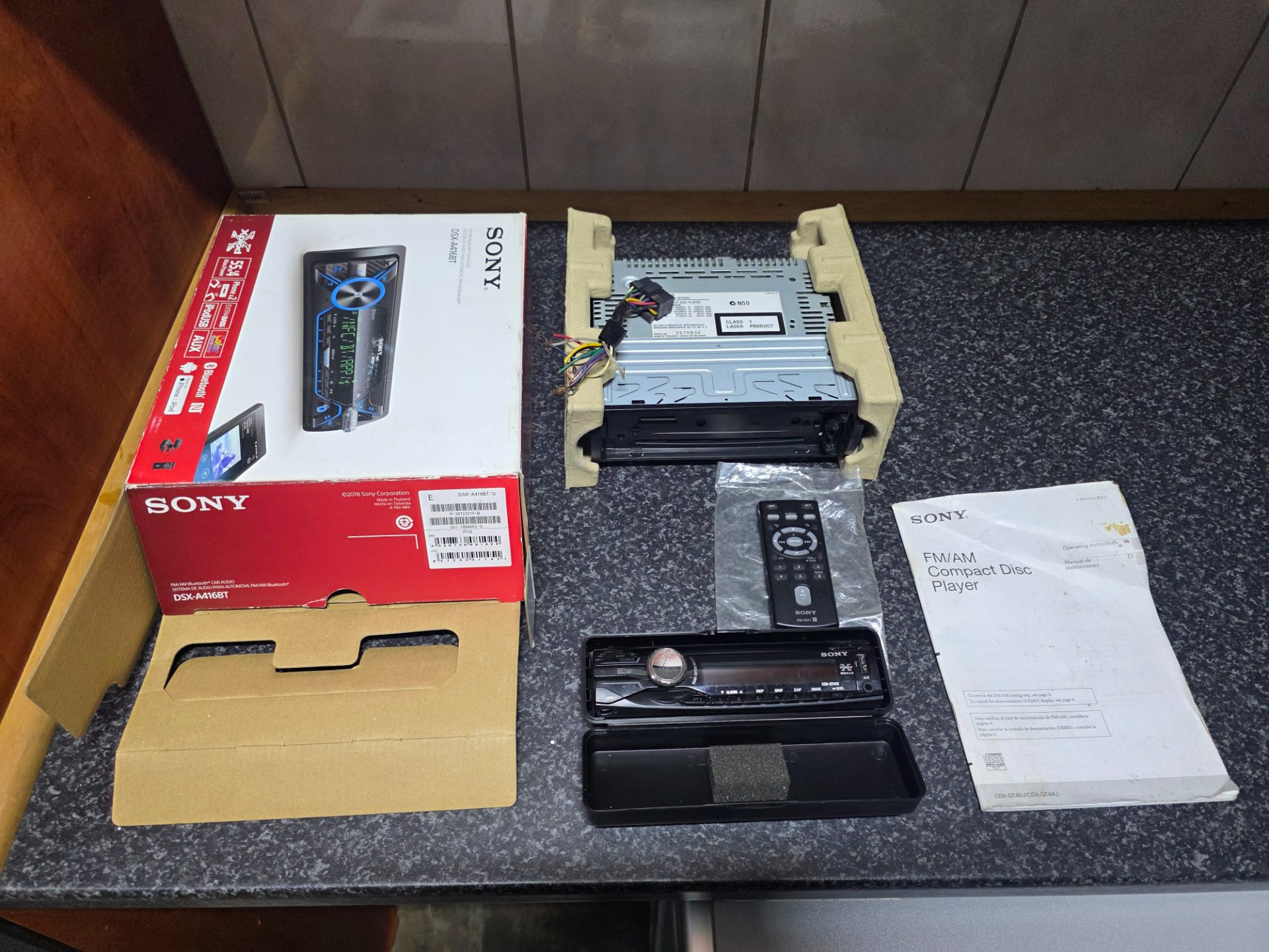 Sony single‑DIN car stereo head unit with detachable face, remote, manual, wiring & box