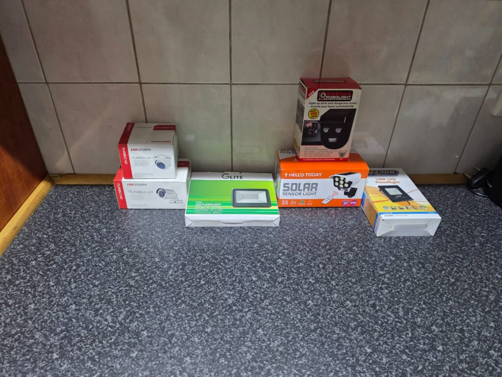 Mixed lot: 6x boxed outdoor/security lights + Hikvision Turbo HD CCTV cameras — brand new sealed (boxes creased)