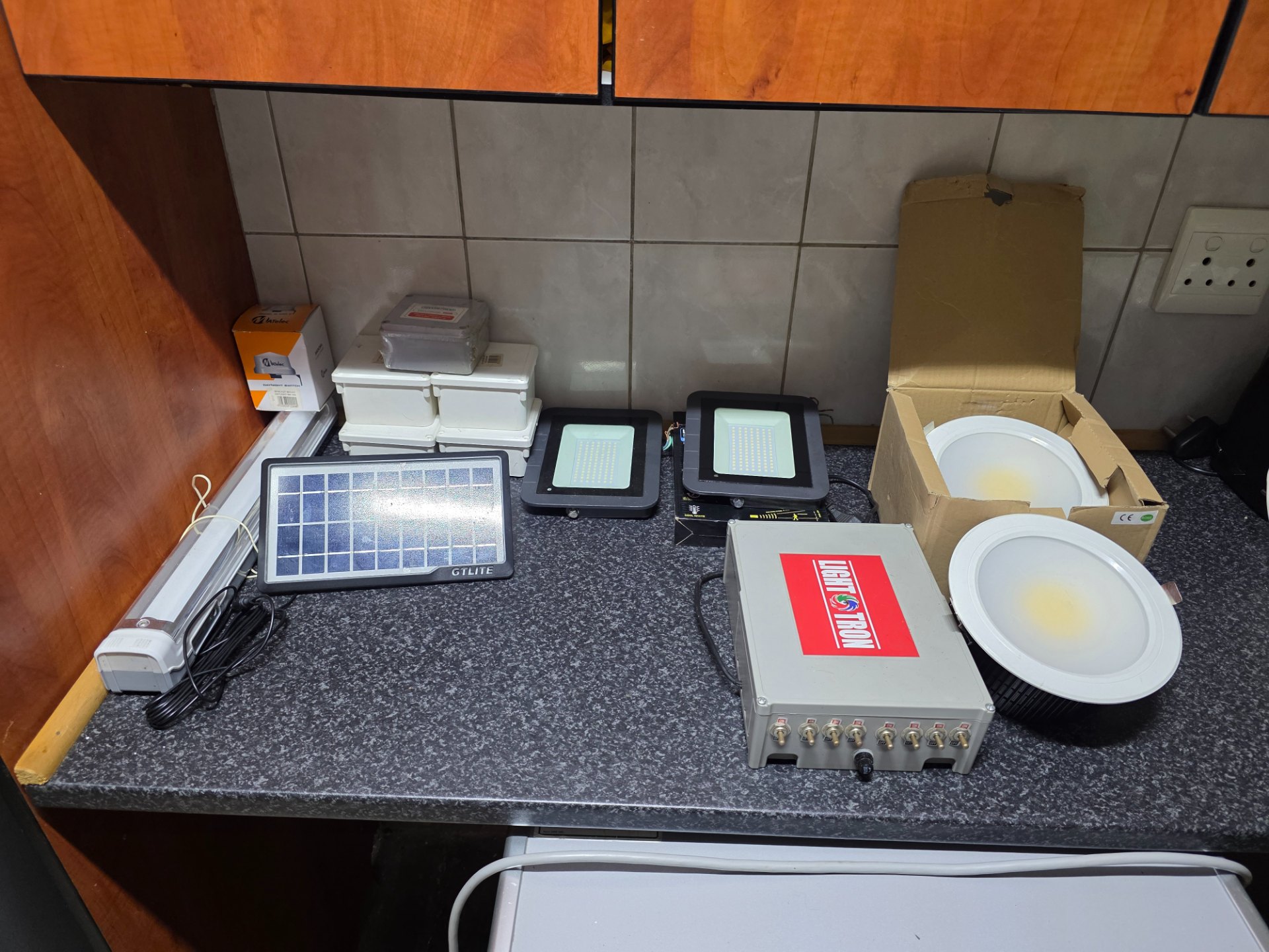 Mixed lot of LED lighting fixtures & accessories — floodlights, downlights, LightTron control box, GTLITE solar panel