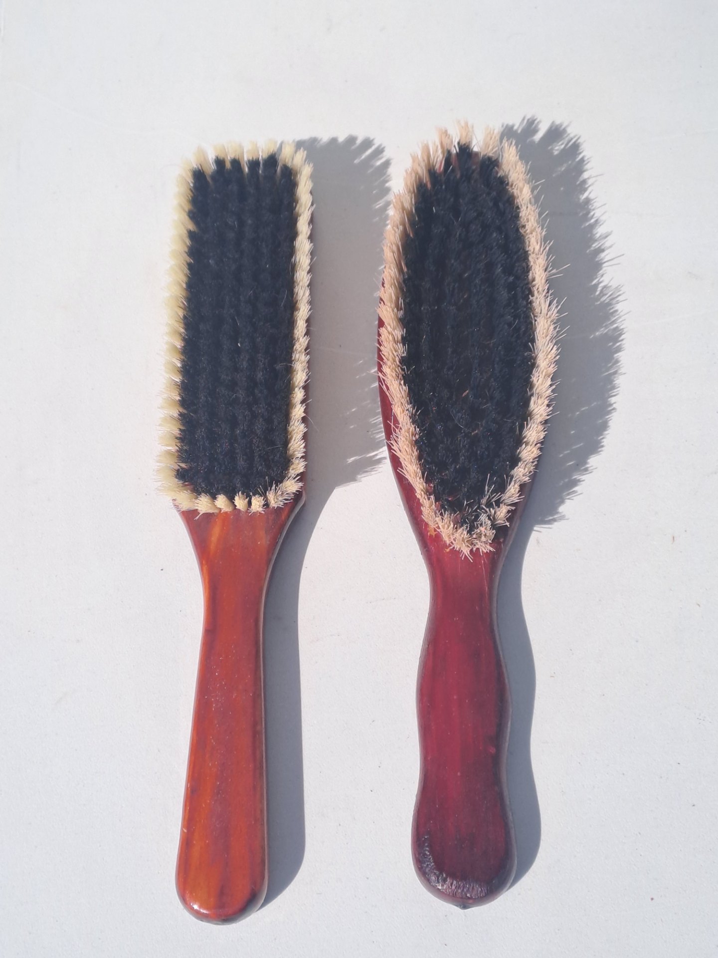Pair of wooden garment brushes — left stamped Tenacity, used (one with worn bristles)