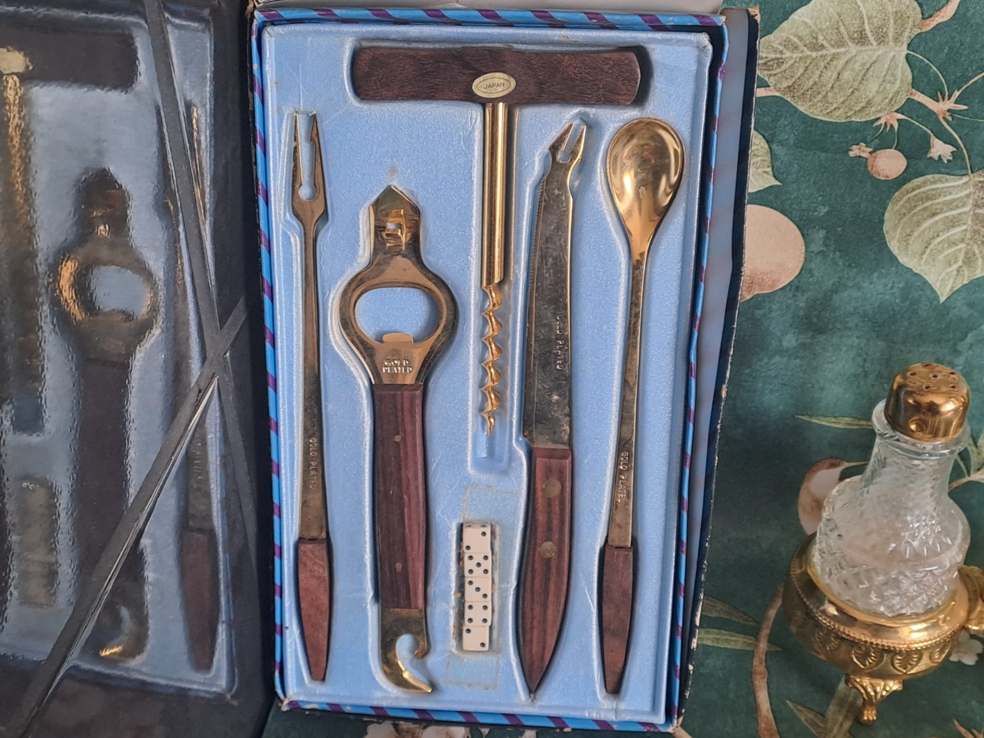 Assorted small metalware & glass lot — boxed ‘Gold Plated’ Japan bar set, cut-glass cruet pair in gilt stand, ashtrays, napkin rings, small scales