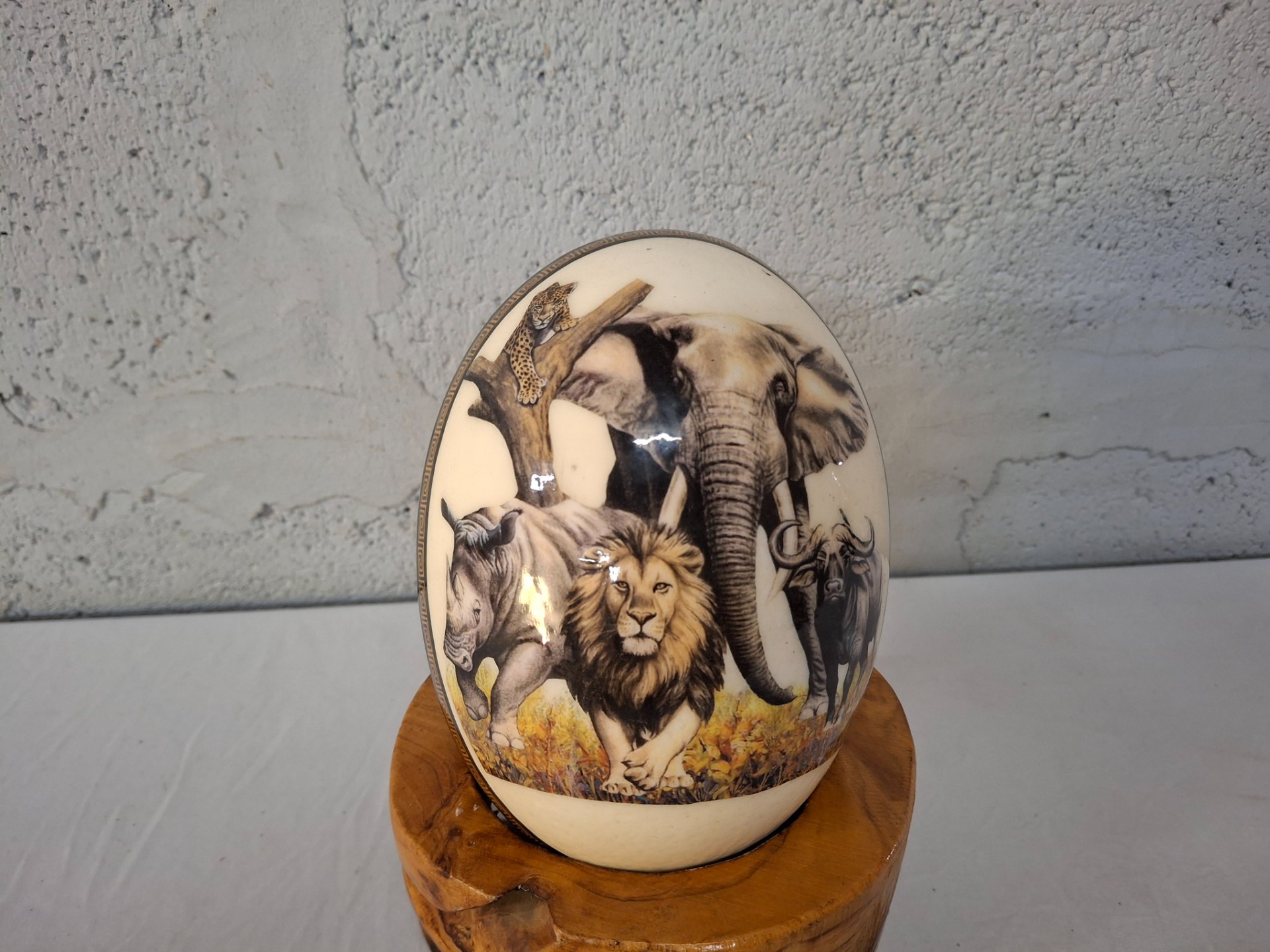 Decorative ostrich eggshell with African wildlife transfer — carved wooden stand included