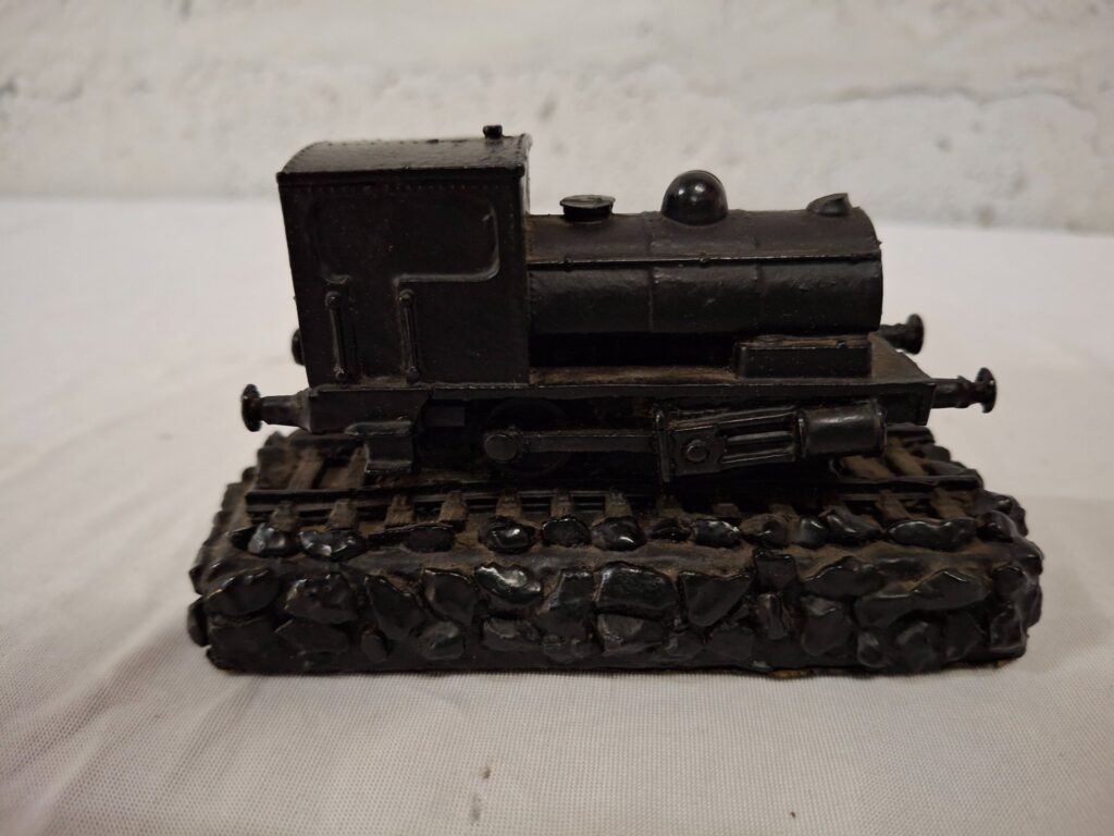 Small resin/plaster decorative steam locomotive on stone-effect base — worn black finish
