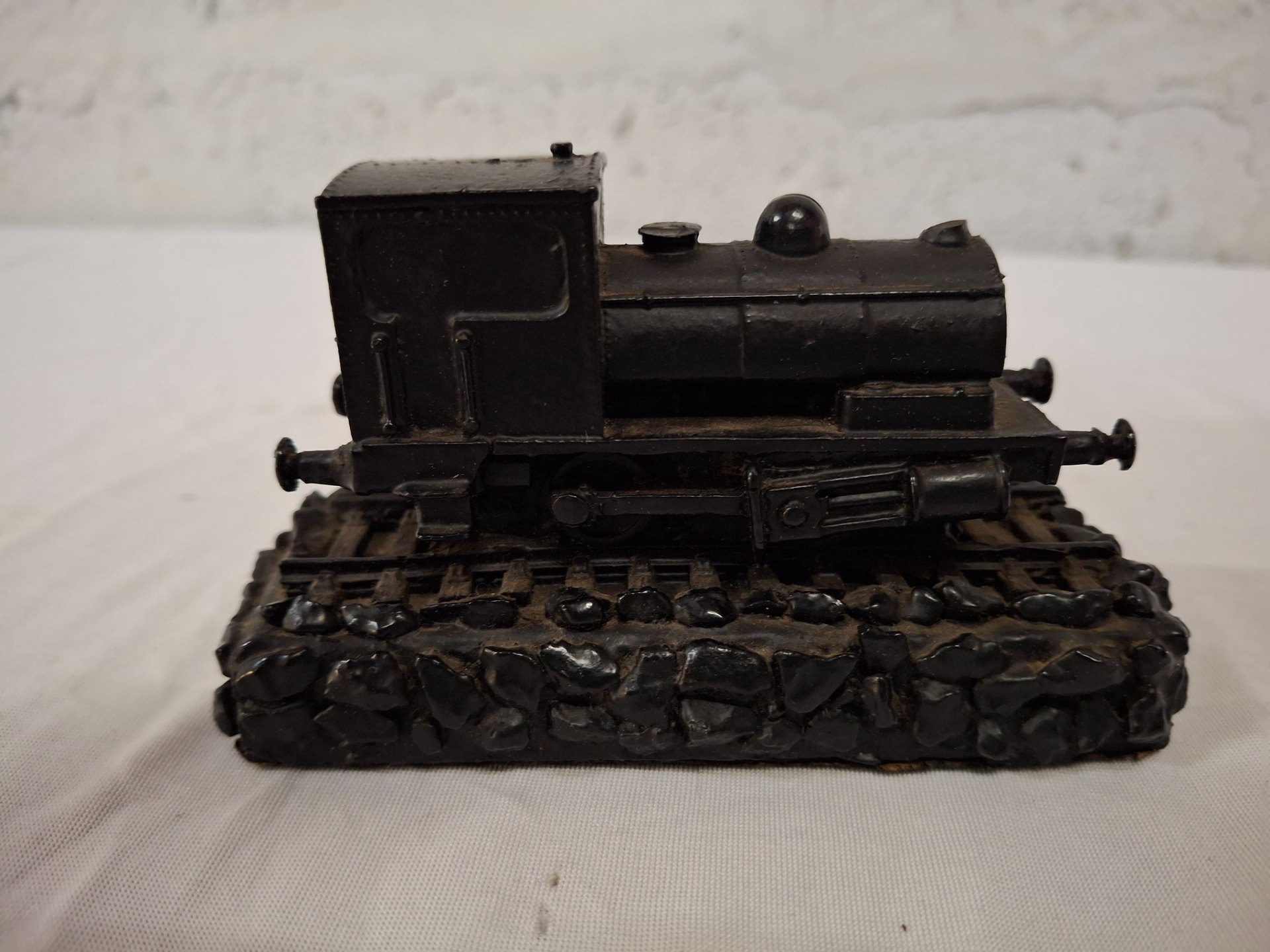Small resin/plaster decorative steam locomotive on stone-effect base — worn black finish
