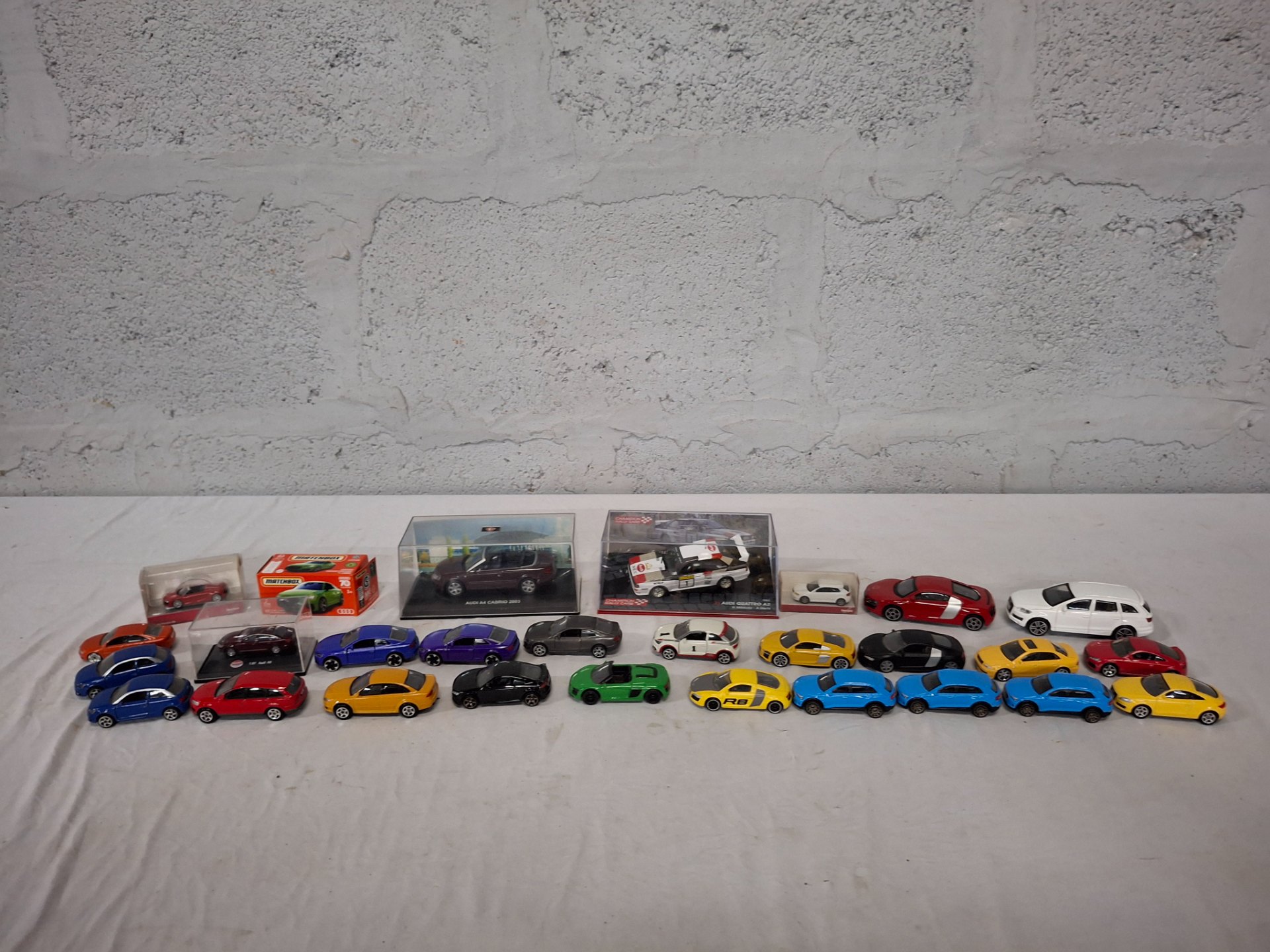 Mixed lot approx. 25 die‑cast toy cars — mostly Audi models, incl. boxed 1:43 & 1:87 examples (Matchbox, Bburago, Majorette, Herpa)