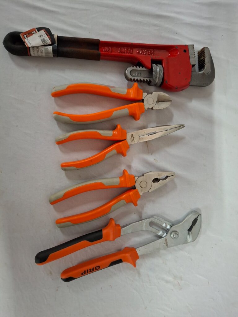 Lot: Assorted hand pliers + heavy-duty 14″ pipe wrench — 5-piece used set (VDE-marked handles, light rust / paint chips)