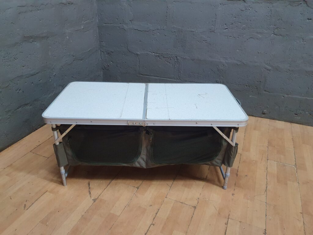 Camp Master fold-flat camping table with attached fabric storage — 118 x 60 x 53 cm (used)