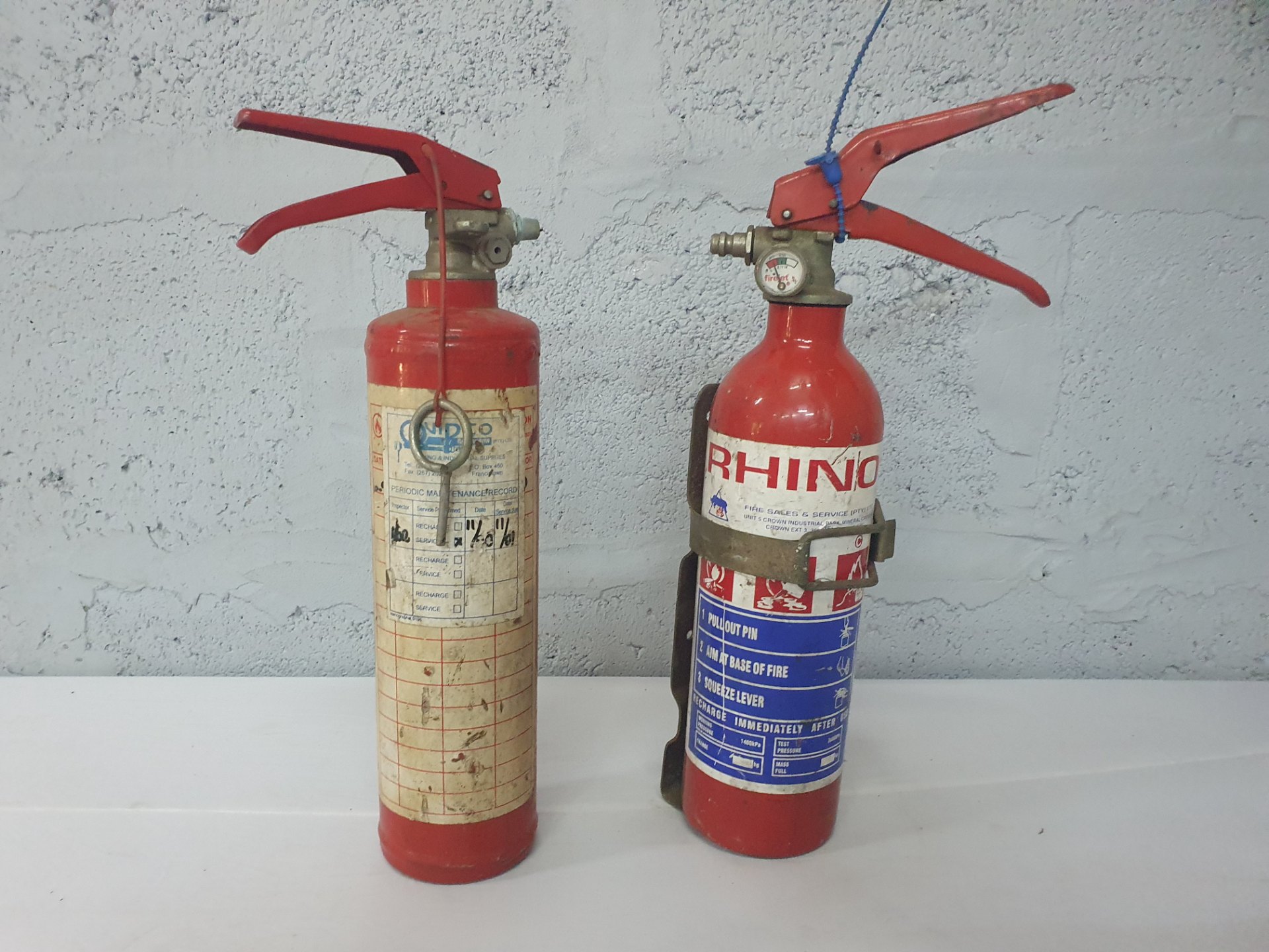 Lot of 2 portable fire extinguishers — one labelled RHINO; used, untested, needs refilling