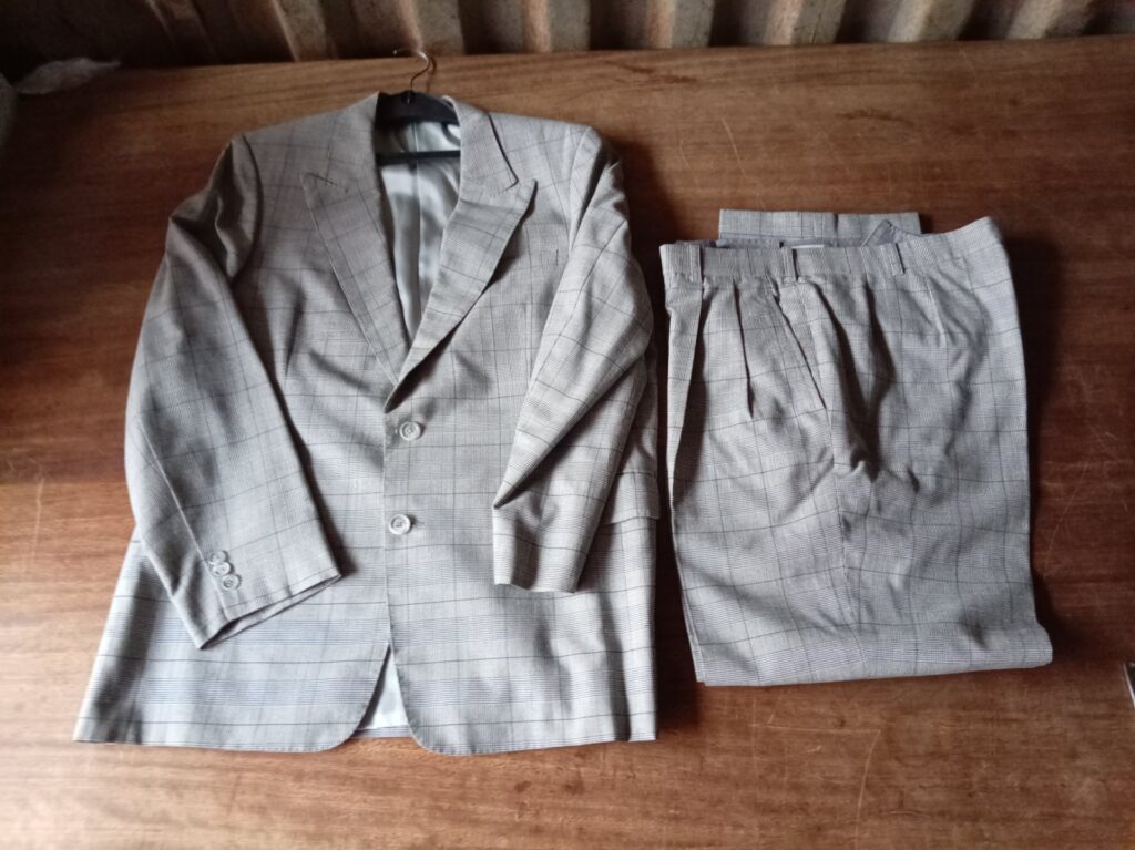 Grey checked men’s two-piece suit — jacket + pleated trousers, lined, buttons present